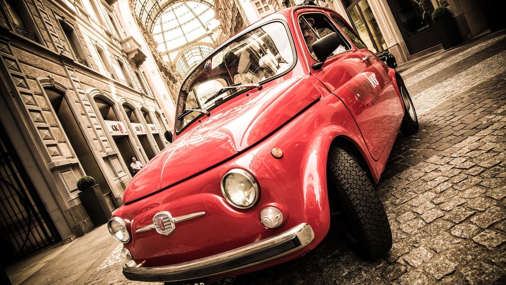 small Fiat car parked on the stone road in Italy