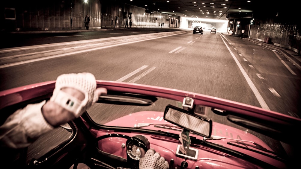 driving a small Fiat car with the top down in Italy