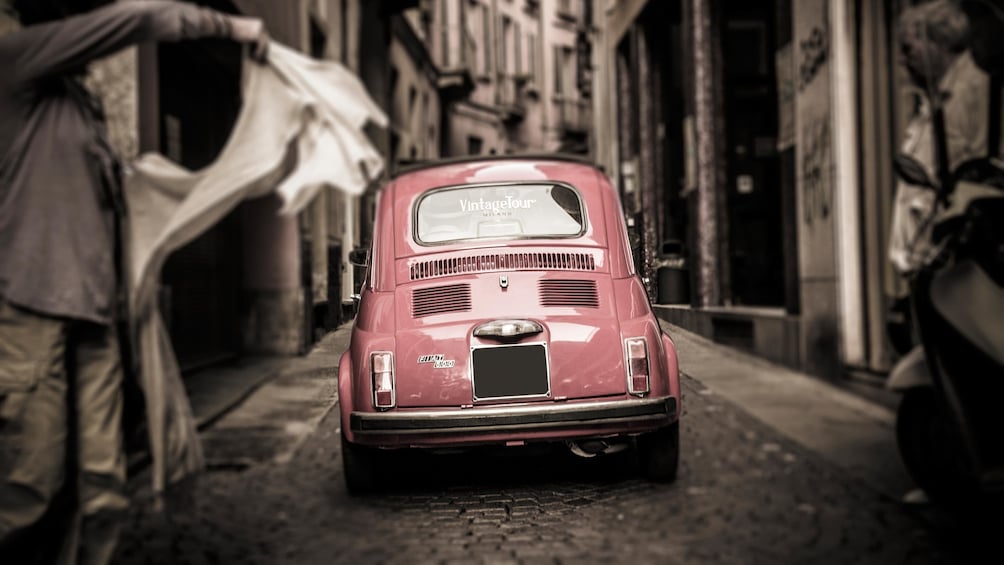 driving a Fiat car through a narrow street in Italy