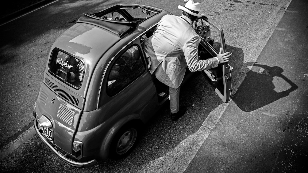 man getting in vintage Fiat vehicle in Italy