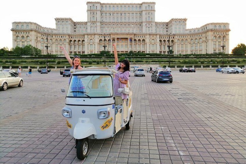 Happy girls in tuk tuk in front of Palace of Parliament