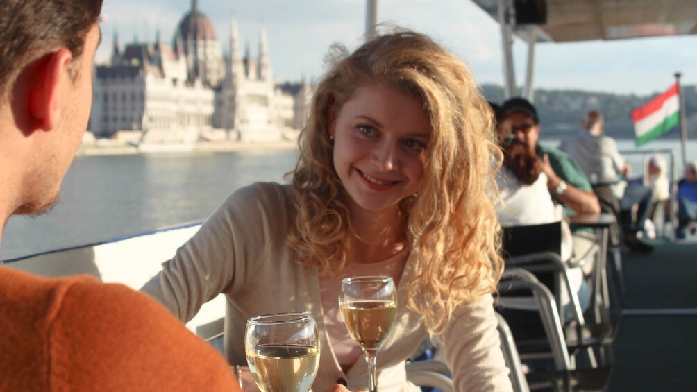 Woman smiles at a man while drinking white wine on a wine cruise