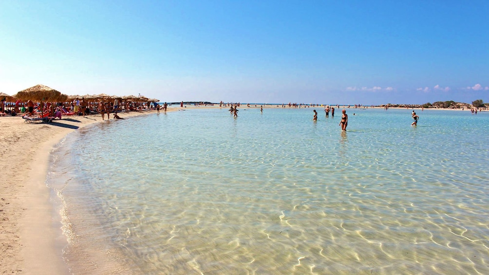 beachgoers enjoying the shallow water in Greece