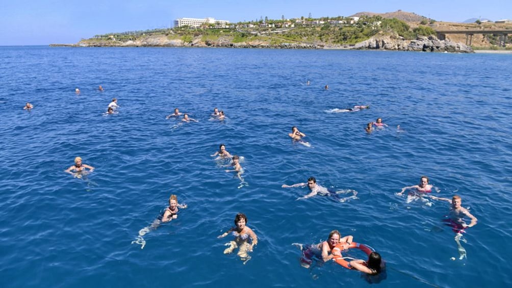 scattered swimmers in the ocean water in Greece