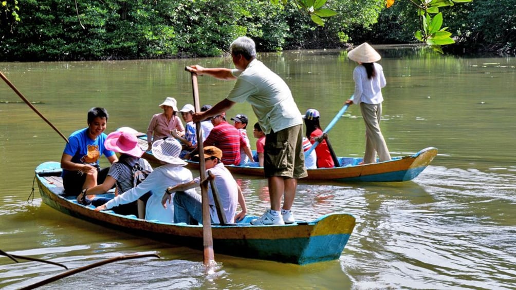 Two tour groups in boats on a river in Vietnam