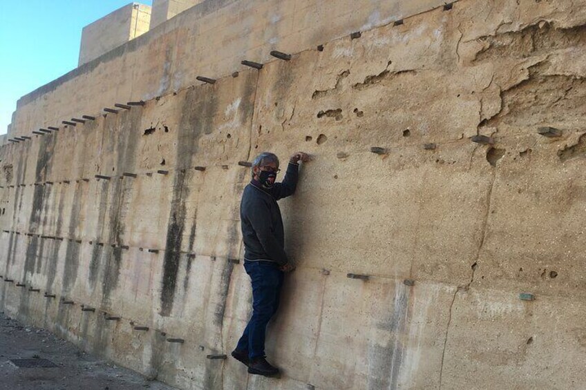 tourist checking mud wall