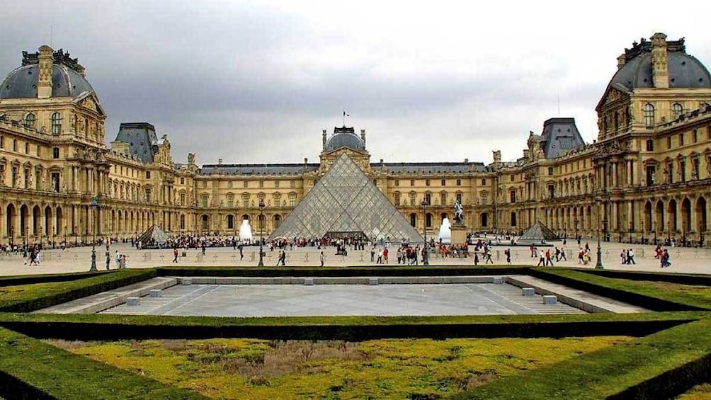 standing at the garden of the Louvre in Paris