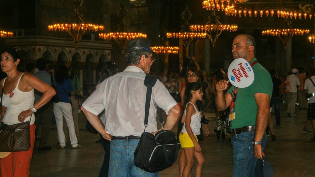 Tourists observing tour guide outdoors.