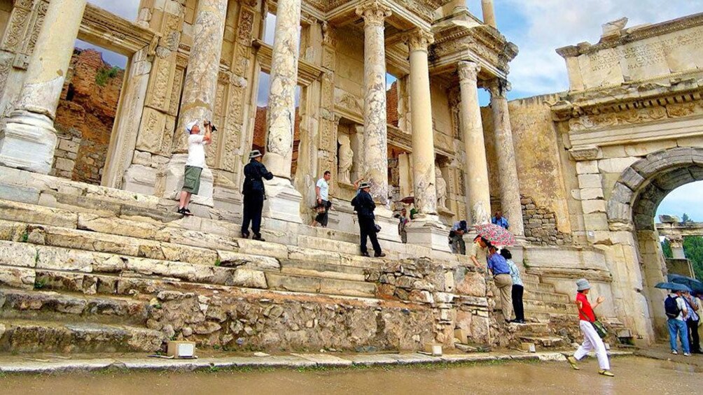 visitors walking up the ruined steps of Ephesus