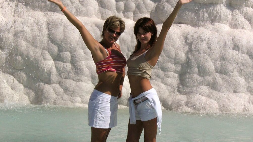 Pair of women standing in one of the hot springs of Pamukkale