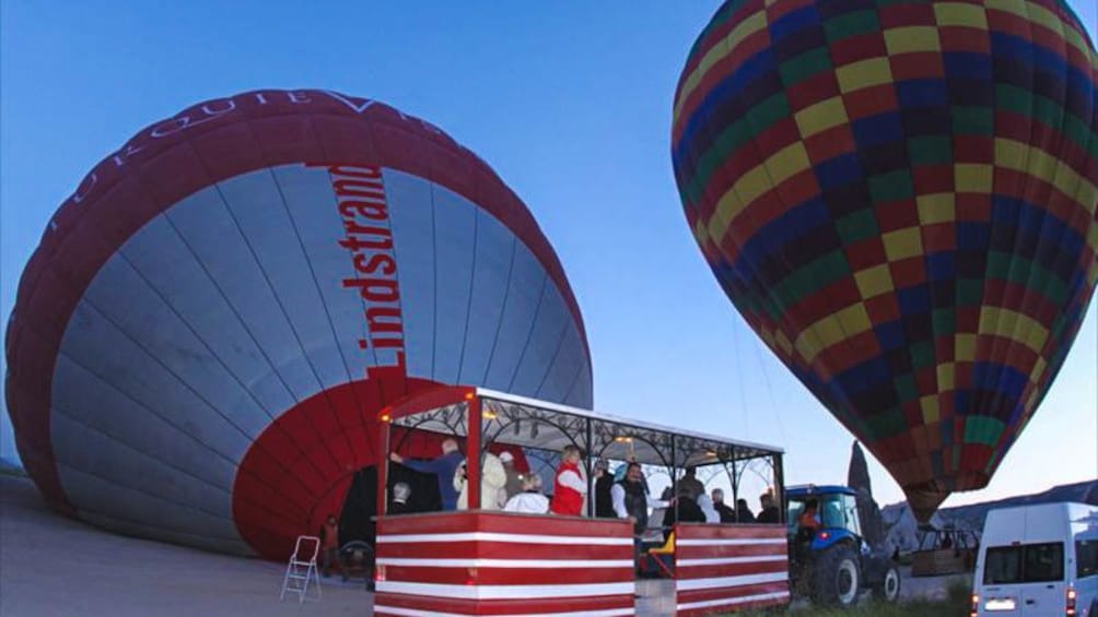 Grounded hot air balloons boarding people.