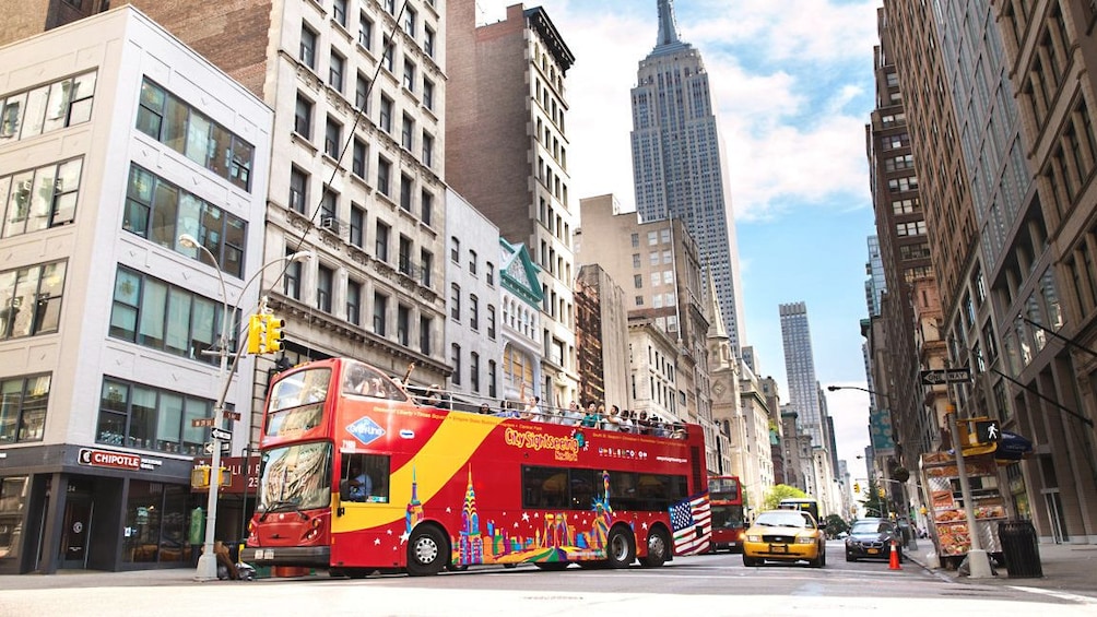 Street view of New York with tour bus carrying several people.