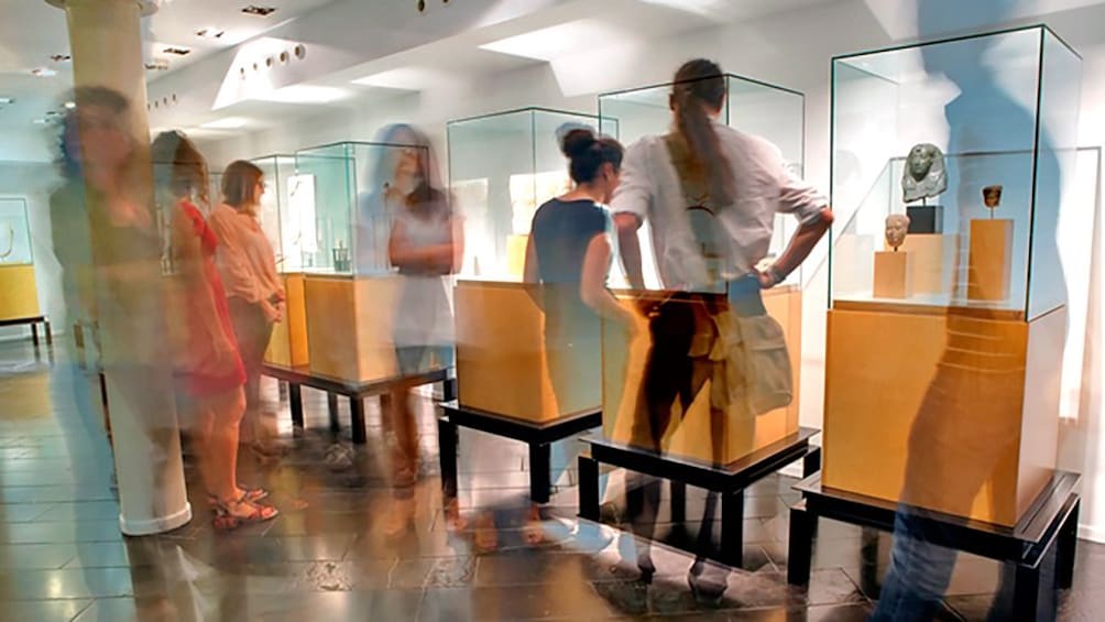 museum visitors looking at artifacts behind glass case in Barcelona