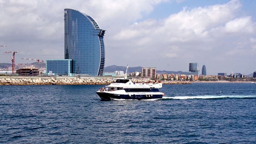 boat coasting by a skyscraper in Barcelona