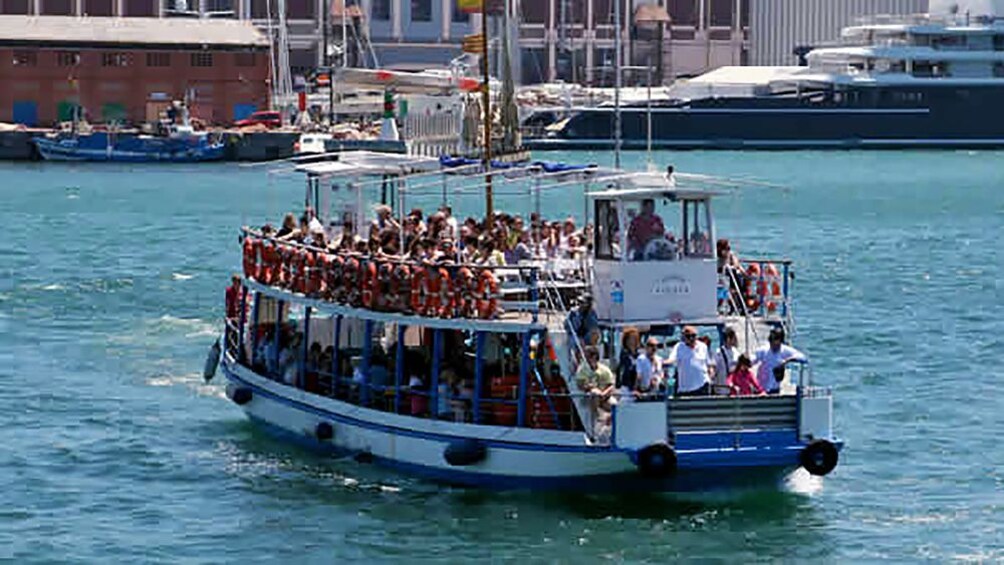 boat full of passengers heading towards the bay in Barcelona