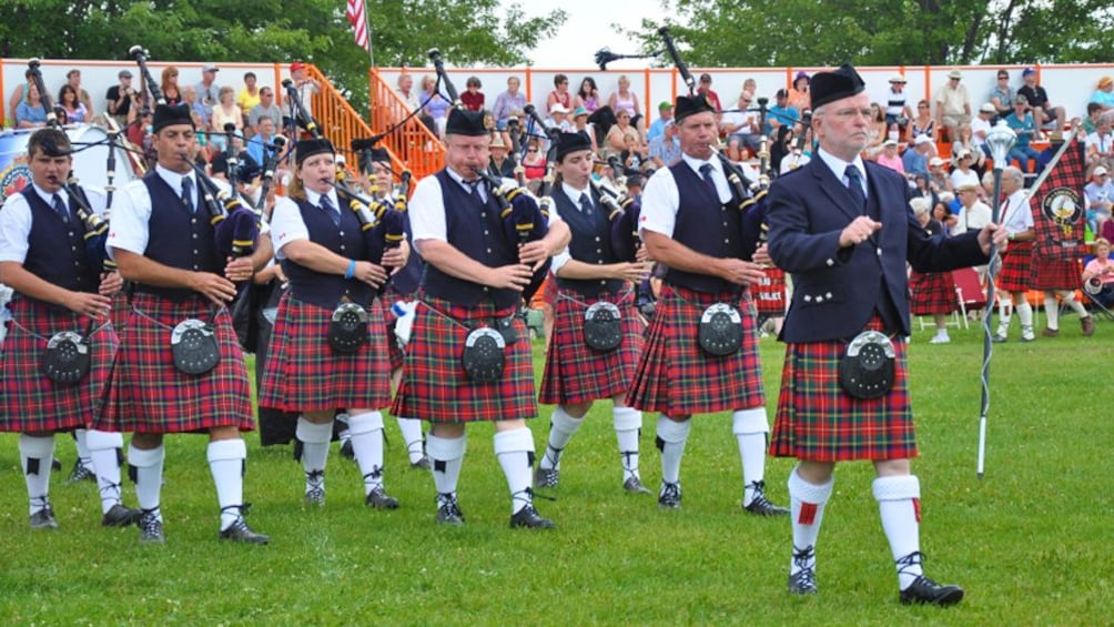 group in traditional kilts playing bagpipe in Scotland