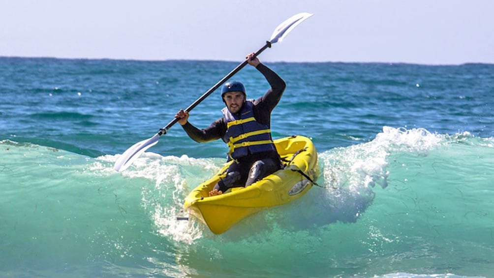 man kayaking through the ocean waves in San Diego