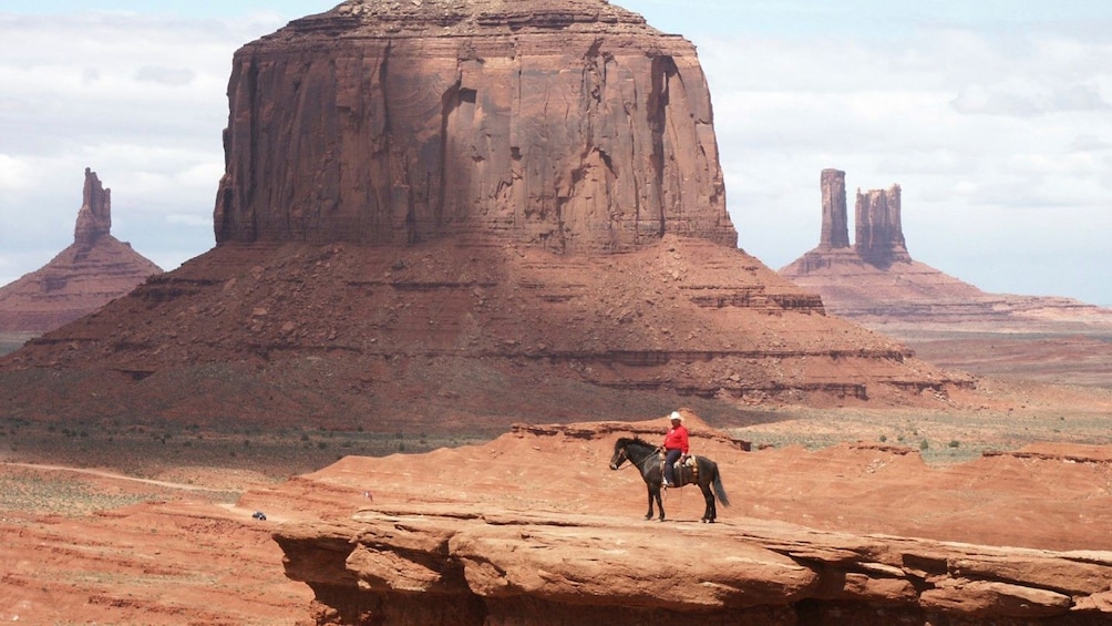 A cowboy on a horse on a cliff in monument park