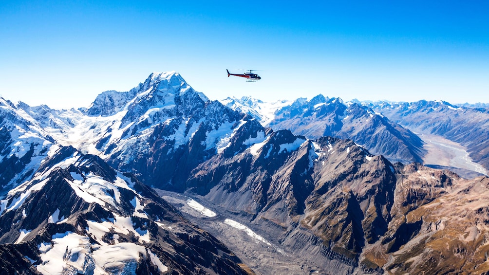 Helicopter flying high past Mount Cook in New Zealand