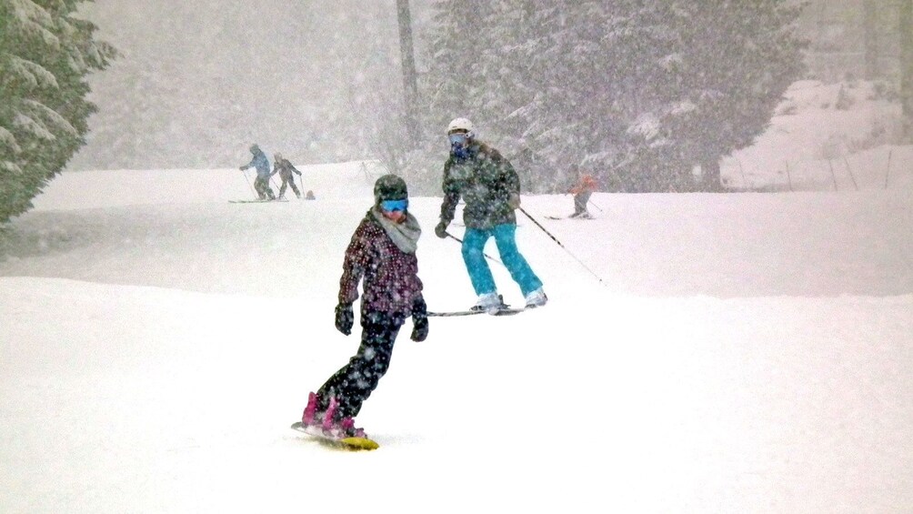 Show item 3 of 4. snowboarding through heavy snow in Whistler