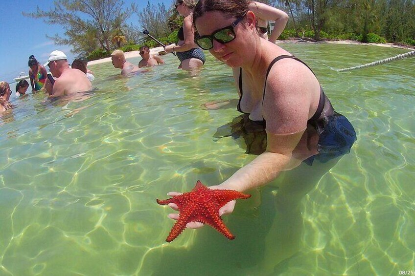Lady holding Starfish in Grand Cayman after tour at Stingray City