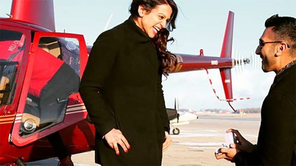 Man proposing to woman next to a flying contraption