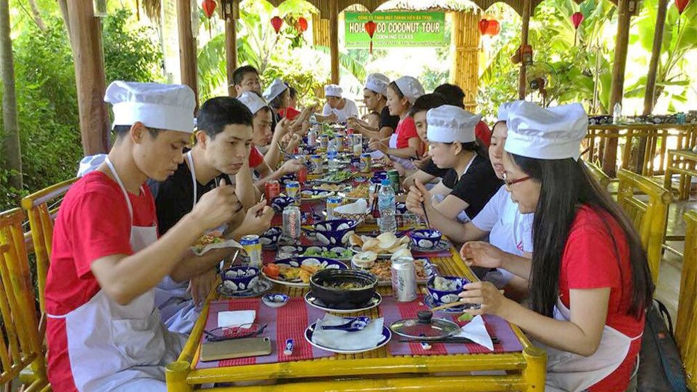 Group enjoying a prepared meal on the cooking class in Hoi An, Vietnam 