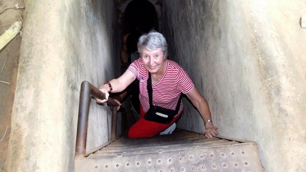 Woman climbing out of the Cu Chi Tunnel in Vietnam 