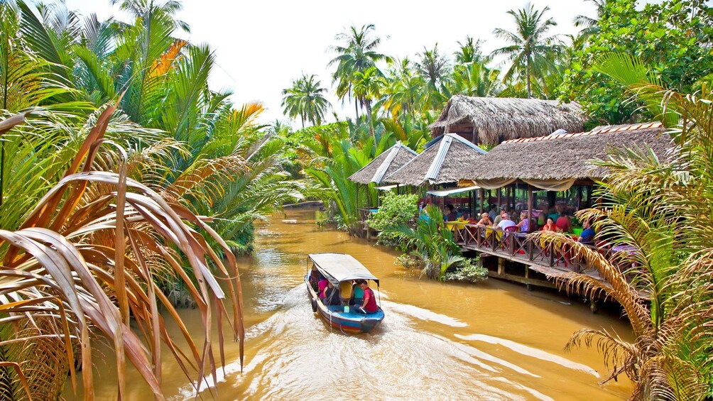 boat passing by dining visitors in Vietnam