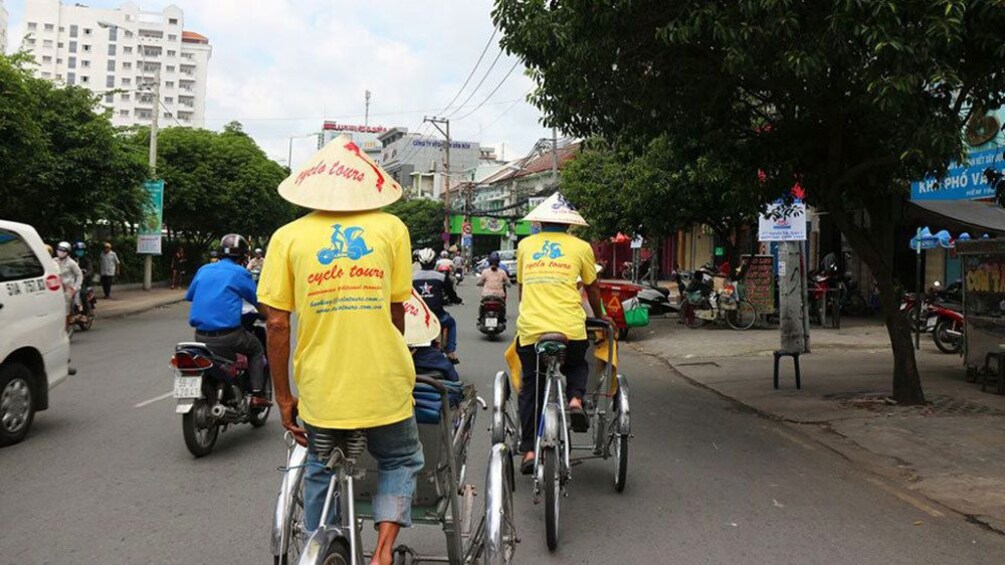 People riding cyclos down street in Vietnam