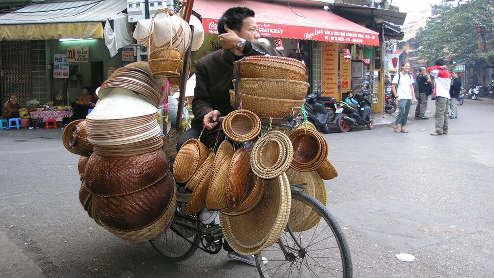 man riding a basket filled bicycle in Hanoi