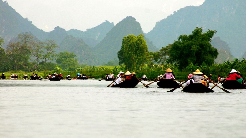 Tour boats on the perfume river in Vietnam with hills in the background