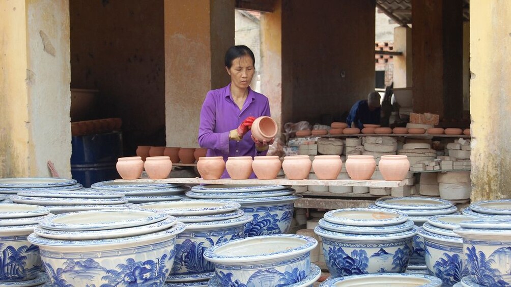 A woman holding pottery in a market in Vietnam