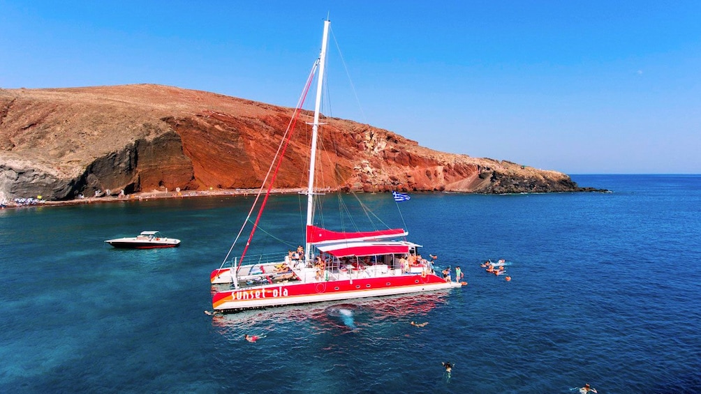 People swimming around the catamaran off of Santorini, Greece