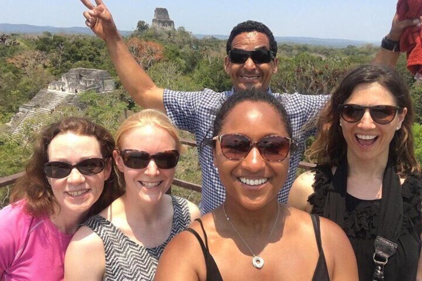 Happy guests on top of the Great Pyramid with one of the tallest pre columbian structures in the Western Hemisphere on the background. Temple IV