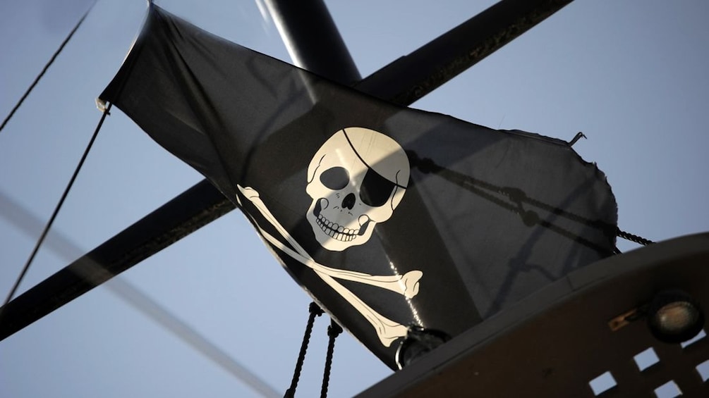 A Pirate flag blowing in the wind on a ship