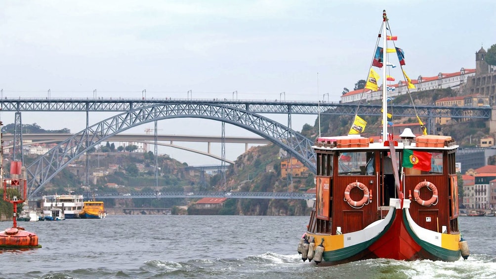boat with colorful flags near the bridge in Porto