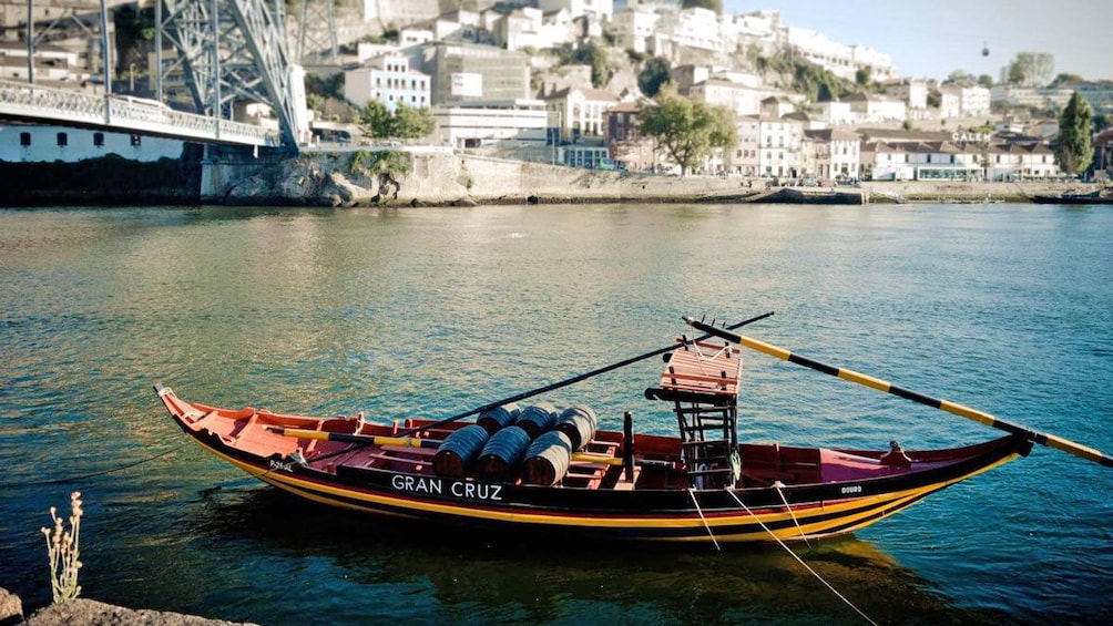 small boat underneath the bridge in Porto
