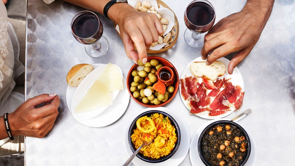 View of tapas on lunch table, served with red wine.