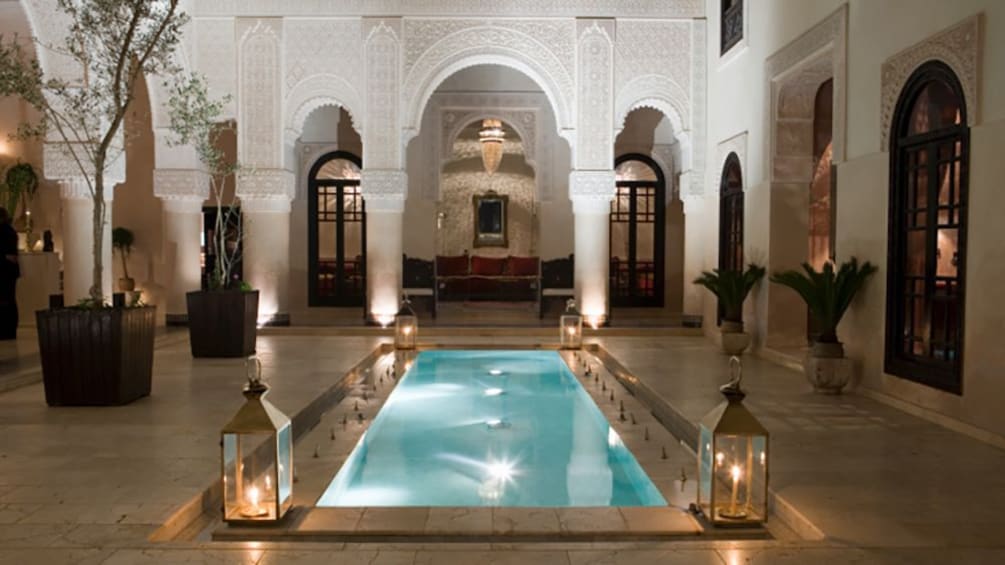 Morrocco, Fez, illuminated pool in courtyard, dusk