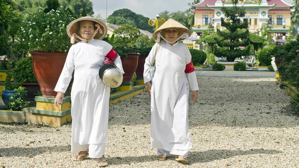 Two women walking with straw hats in Vietnam