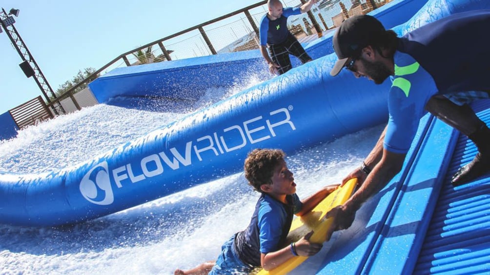 Foto 3 van 5. Lifeguard assisting young visitor on water slide.