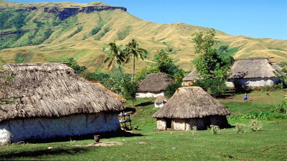 Thatched huts with mountains in the background in Fiji