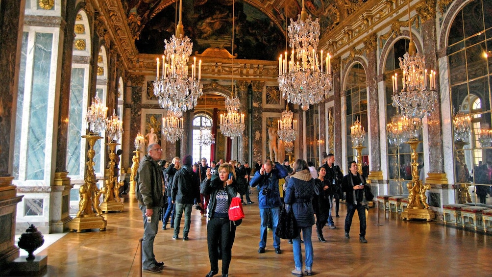 walking through the ornamented hallways inside the Versailles Palace in France