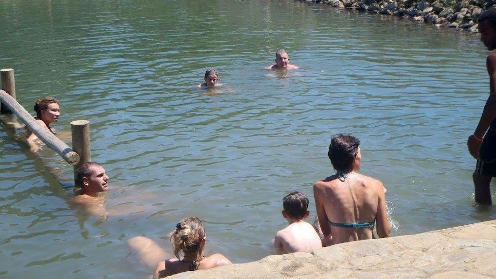 People relaxing in a mud pool in Fiji