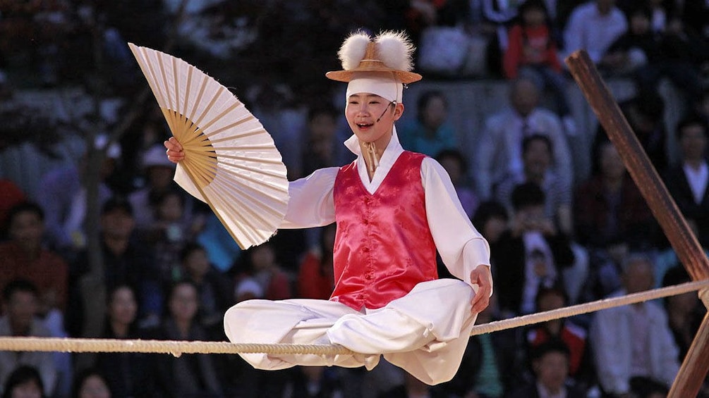 man in show sitting on top of rope