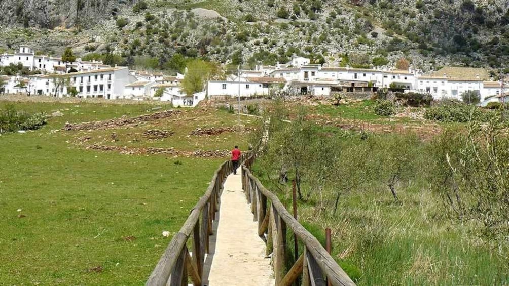 walking on a narrow wooden path towards a town in Spain