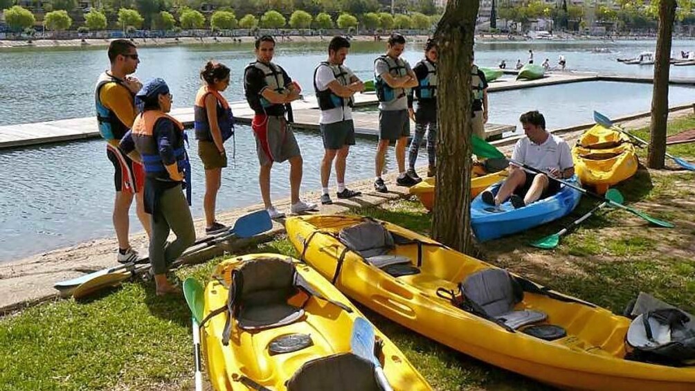 group sorting out kayaks along the water in Spain