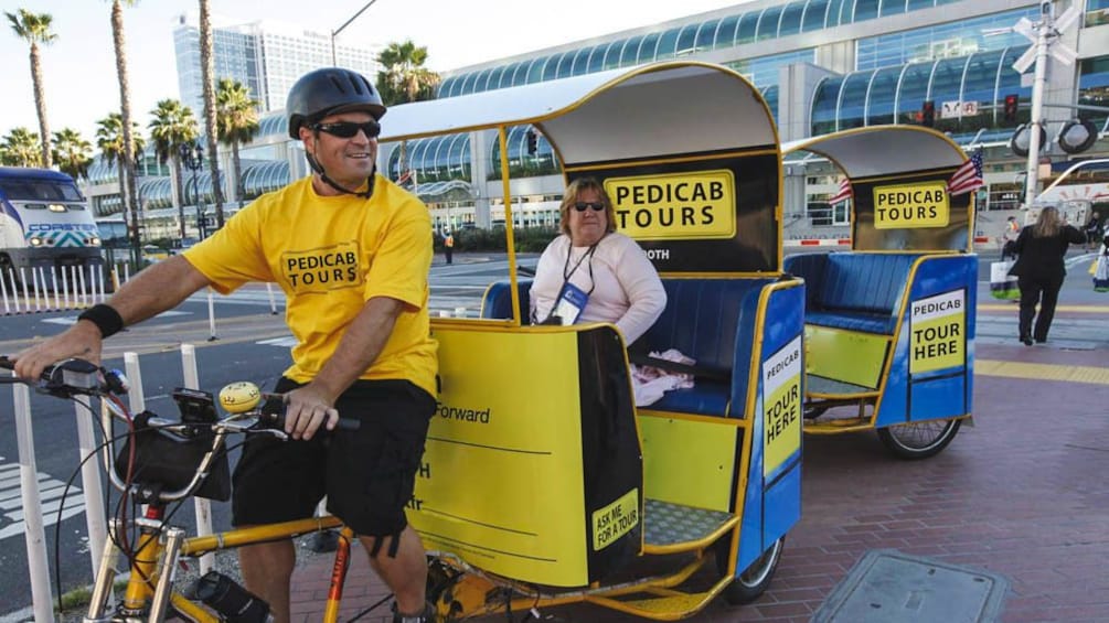 Woman on pedicab with driver in front.