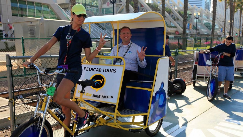 Man in a pedicab with driver in San Diego